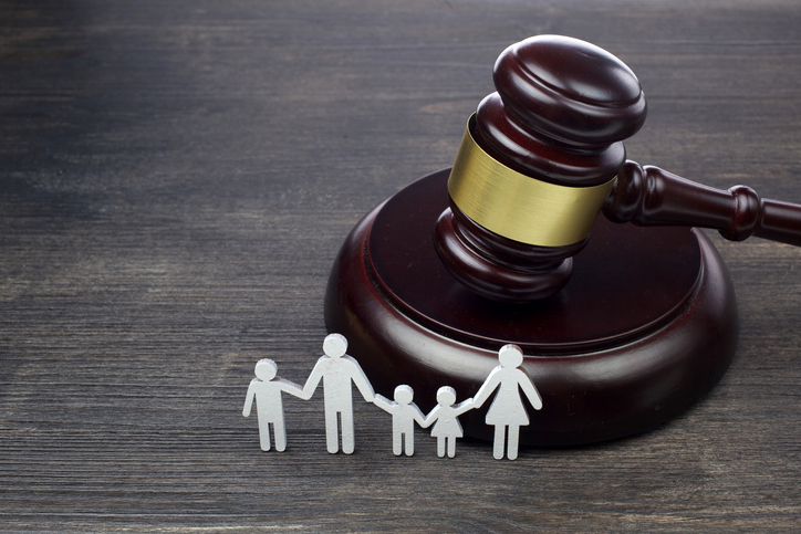 Family figure and gavel on wooden background. Family law concept